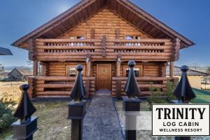 una baita di tronchi con una recinzione di fronte ad essa di TRINITY Log Cabin Wellness resort a Štrba