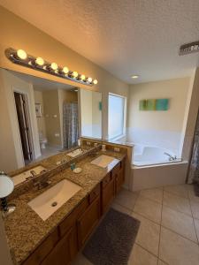 y baño grande con 2 lavabos y bañera. en Amazing Retreat at Lake Berkley, en Kissimmee