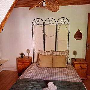 - une chambre avec un lit doté d'une tête de lit en métal dans l'établissement Maison de Bourg, à Rochefort-Montagne