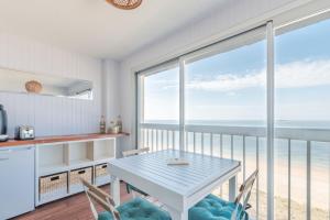 a kitchen with a table and chairs with a view of the ocean at LE PANORAMIQUE - Face mer - Wifi in Pornichet