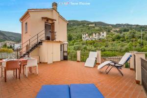 een balkon met een tafel en stoelen en een gebouw bij La Goletta, Terre Marine in La Spezia
