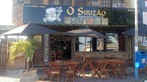 un restaurante con mesas y sombrillas frente a él en Pousada Pé na Praia, en Rio das Ostras 4 fotos más