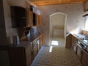 a kitchen with wooden cabinets and a tile floor at Pvt Guesthouse 2 hour Stay Booking in Johannesburg +19 photos