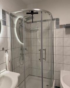 a shower in a bathroom with a sink and a toilet at Zechenstube in Elbingerode +20 photos