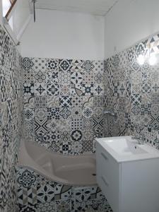 ラヴラネにあるAppartement 2 chambres et salon de massageのタイル張りのバスルーム(バスタブ、シンク付)