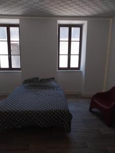 ラヴラネにあるAppartement 2 chambres et salon de massageのベッドと2つの窓がある寝室