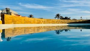 a person standing next to a pool of water at F3Sun CASA JACOB - 2 BR, Green Oasis, Costa Calma, Fuerteventura in Costa Calma