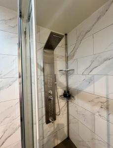 a bathroom with a shower with white marble walls at Athenian Retreat Penthouses in Athens +37 photos
