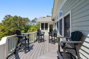 a deck with chairs on the side of a house at Ocean Escape in Corolla