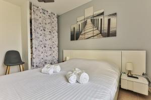 a bedroom with a bed with two towels on it at Le Dôme - Piscine - Parking - Jardin in Commequiers