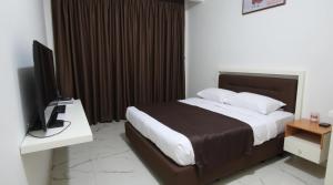 a bedroom with a bed and a desk with a television at Punarvika Bay Villa in Puttalam