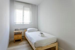 a small bedroom with a bed and a window at Epalza apartment by People Rentals in Bilbao