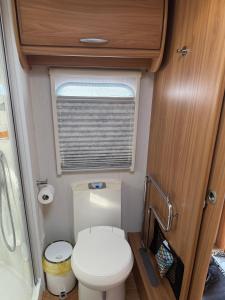 un piccolo bagno con servizi igienici in un camper di Peaceful Caravan Escape a Costa da Caparica