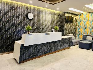 瓦拉纳西Trimrooms Banaras Station的大堂的前台,墙上挂着时钟