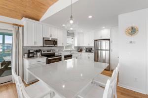 Southern ShoresにあるOcean Havenの白いテーブルと椅子のある白いキッチン