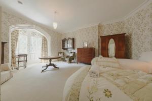 Un dormitorio con una cama grande y una mesa. en Rural Victorian Mansion, en Wrington
