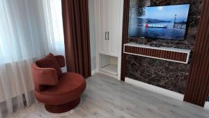 a living room with a chair and a television at BLU MARK Otel in Kozlu