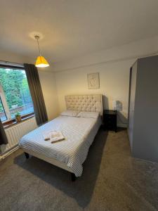 a bedroom with a bed with a towel on it at Four BDR House By Eason Stays Short Lets & Serviced Accommodation Rugby With Free Parking in Hillmorton