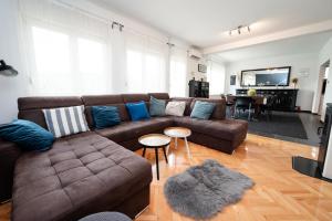 a living room with a brown couch and blue pillows at Villa Ema in Drniš