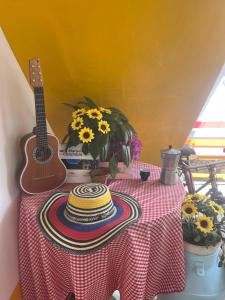a table with a guitar and a stack of plates at Hospedaje El Encanto in Zipaquirá +29 photos