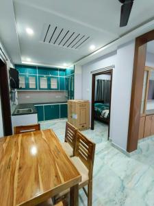 a kitchen with a wooden table in a room at Comfortable Budget Stay at ServoStay NonAC Rooms in Tirupati Ideal for Pilgrims in Tirupati