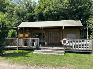 a small house with a porch and a tent at Koelioere Glamping Tent in Biddinghuizen