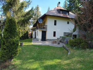 a large white house with a porch and a yard at Vlasic Relax in Vlasic