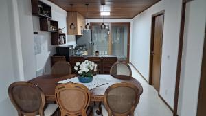 a dining room table with chairs and a vase of flowers at Villa Andorinha, Apt 03 in Mucugê