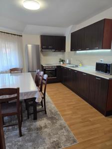 a kitchen with a table and chairs and a kitchen with a sink at Apartment VEDA 2 in Veliko Tŭrnovo