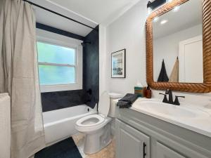 un bagno con un water, un lavandino e uno specchio di Chic Lakeside Retreat Steps from the Beach a Cleveland