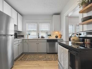 una cucina con mobili bianchi e un piano di lavoro di Chic Lakeside Retreat Steps from the Beach a Cleveland Altre 16 foto