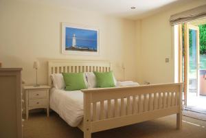 a bedroom with a bed with green pillows at House 32 in Looe +28 photos