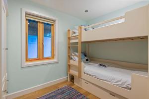 a bedroom with two bunk beds and a window at House 35 in Looe