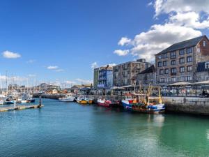 a group of boats are docked in a harbor at Kings Cross by Pureserviced in Plymouth
