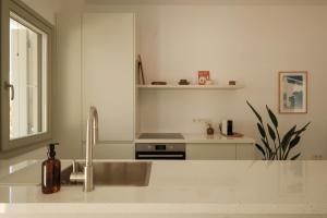 a white kitchen with a sink and a sink at Mazi Paros in Aliki +43 photos