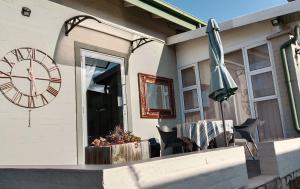 a clock and an umbrella on the side of a house at 712@Rest in Dullstroom