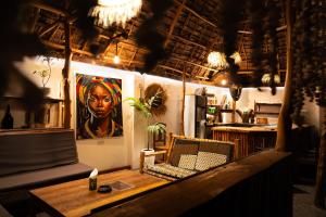 a room with a table and a portrait of a woman at Tribe Bungalows, Bwejuu, Zanzibar in Bwejuu