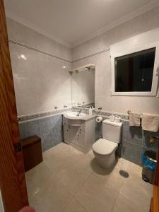 a bathroom with a toilet and a sink and a television at Westmorland in Busot