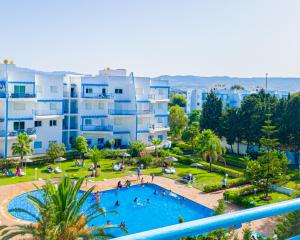 a view of a swimming pool in a park with buildings at Résidence Riviera beach in Cabo Negro