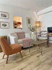 a living room with a couch and a table at Le petit traîne-feuilles in Saint-Aignan