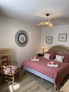 a bedroom with a bed and a chair and a mirror at Le petit traîne-feuilles in Saint-Aignan