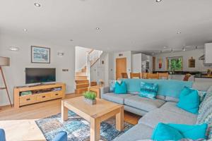 a living room with a blue couch and a table at House 4 in Looe