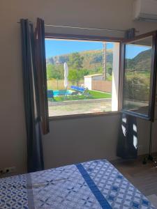 a bedroom with a window with a view of a pool at La Case in Rosières