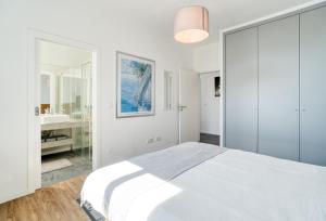 a white bedroom with a bed and a bathroom at Casa Luz by LovelyStay in Prazeres +26 photos