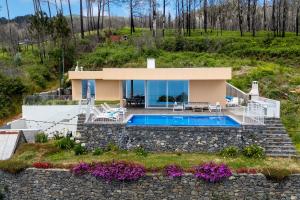 a villa with a swimming pool and a house at Casa Luz by LovelyStay in Prazeres