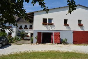a white house with red doors and flowers on the windows at Lindenhof Hahn in Blankenrath