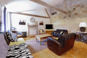 CléguérecにあるGites Les Hibouxのリビングルーム(革製家具、テレビ付)