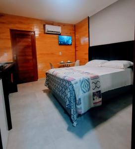 a hotel room with a bed and a table and a television at UrbanStay Flats in João Pessoa