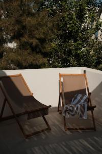 a wooden rocking chair sitting on a patio at Mazi Paros in Aliki