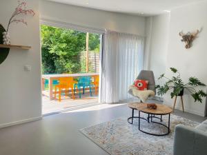 a living room with a chair and a table at Deining in Sint Maartensvlotbrug
